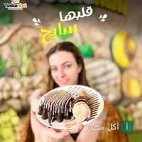 فتاة تقدم طبق حلويات بالشوكولاتة والآيس كريم في مطعم وكافيه توسكانيني بطنطا.