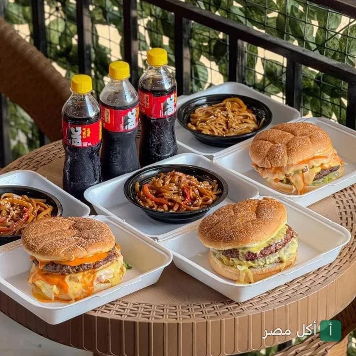 وجبات برجر مع مكرونة وزجاجات كولا في مطعم الدوكش بطنطا.