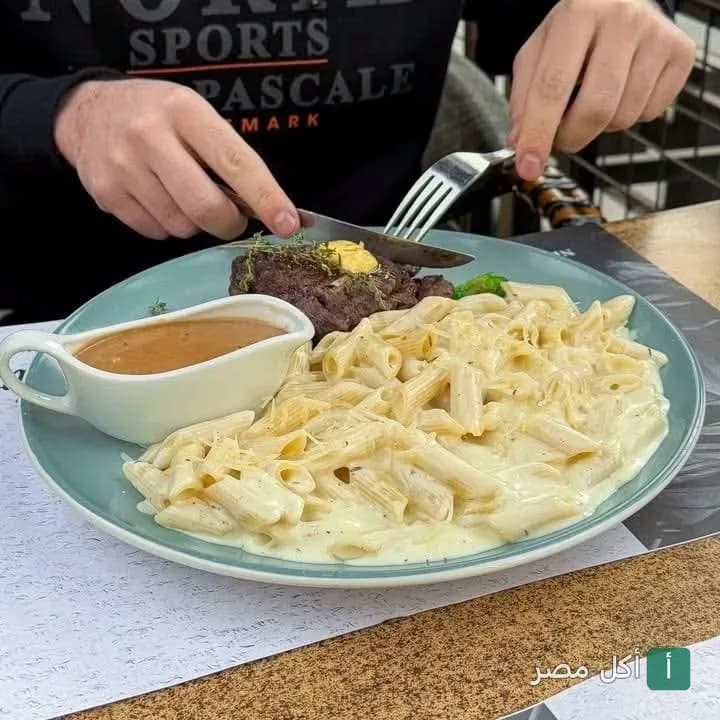 طبق مكرونة بالصوص الأبيض مع قطعة ستيك وصوص جانبي في مطعم فريسكي بطنطا.