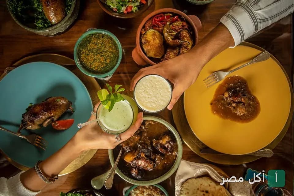 مائدة طعام شرقية متنوعة في مطعم الخال المصري بالقاهرة تضم مشاوي وأطباق طواجن ومشروبات منعشة.