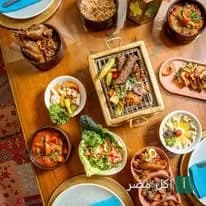مائدة طعام متنوعة تضم أطباق مشاوي شرقية ومقبلات في مطعم الخال المصري بالقاهرة.