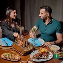 رجل وامرأة يتناولان المشاوي في مطعم الخال المصري بالقاهرة.