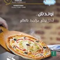 بيتزا ساخنة تقدم على لوح خشبي في مطعم وكافيه اولدش بالقاهرة.