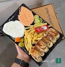 طبق مشاوي من مطعم تبولة في القاهرة يضم شاورما مع بطاطس مقلية وثومية ومخلل