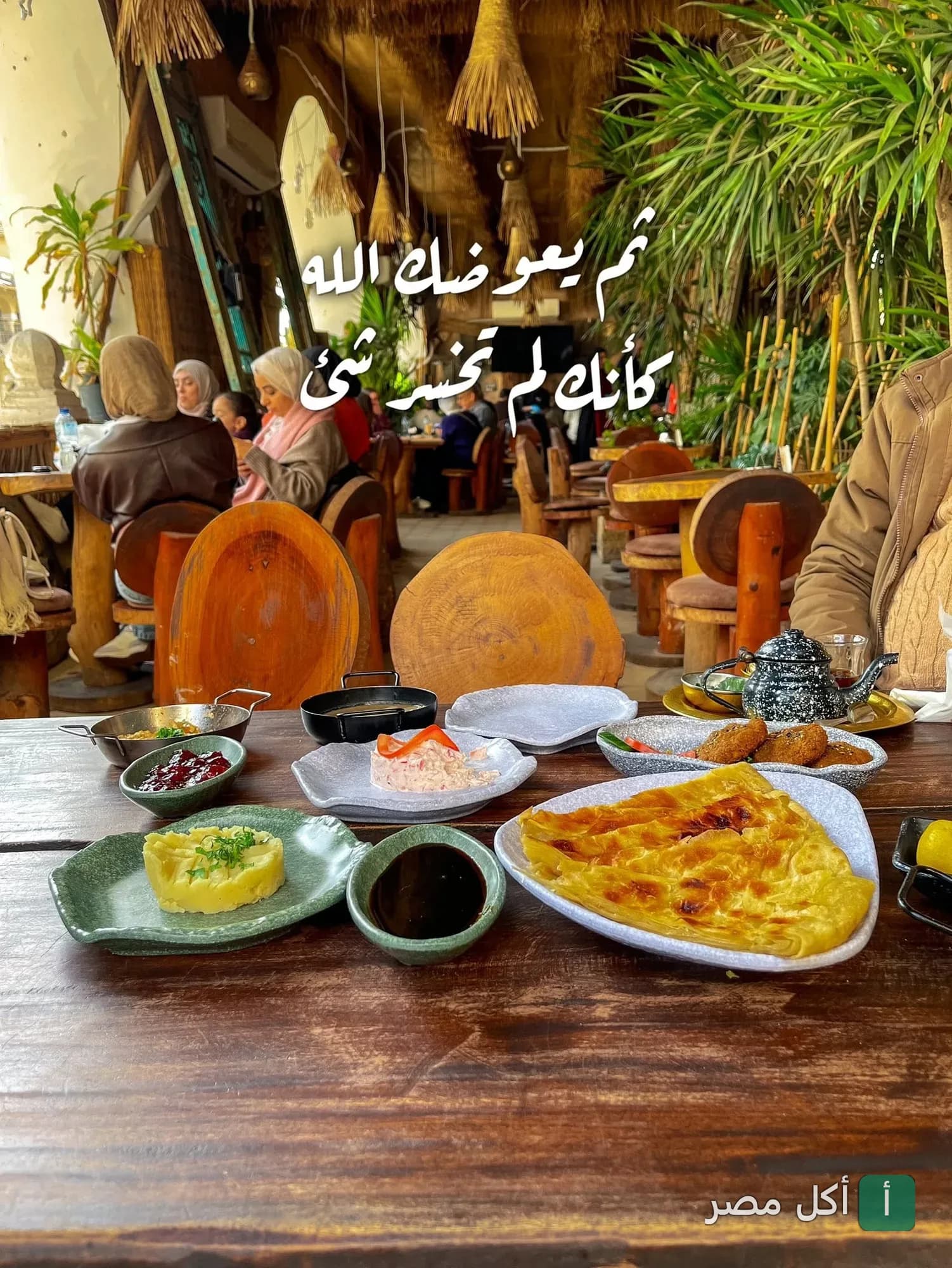 مائدة إفطار شرقي متنوعة في مطعم الكوخ بالقاهرة، مع ديكور خشبي وأجواء ريفية دافئة.