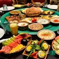 مائدة إفطار مصرية متنوعة تضم أطباق فول وطعمية وبيض وخضروات في مطعم أبو السيد بالقاهرة.