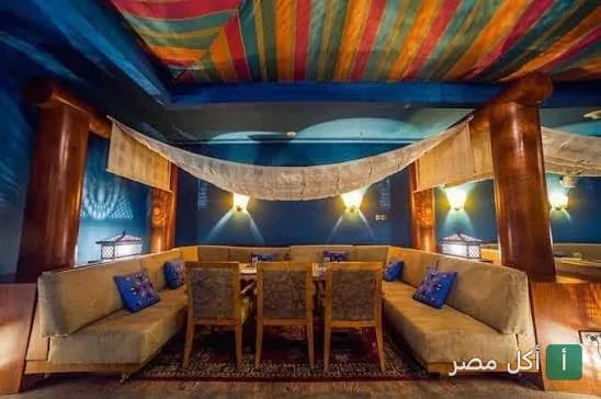 جلسة شرقية مريحة بديكورات خشبية وأقمشة ملونة في مطعم باب الشرق بالقاهرة.
