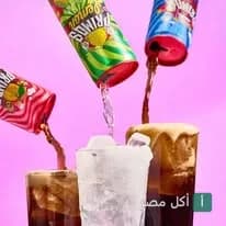 مشروبات غازية من بريموز بيتزا تُصب في أكواب مثلجة على خلفية وردية.