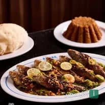 طبق سمك مشوي مع الليمون وأرز الصيادية في مطعم أسماك بمارينا العلمين.