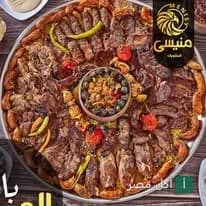 صينية مشويات مشكلة من مطعم منيسي في مارينا العلمين، تحتوي على كباب وكفتة مع خضروات مشوية.