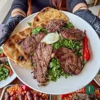 طبق مشويات متنوع مع خبز وبقدونس من مطعم مشويات أبو ربيع في برج السينما بمنيا القمح.