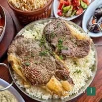 طبق مشويات من مطعم أبو ربيع في منيا القمح، يقدم اللحم المشوي على أرز أبيض مع أطباق جانبية من السلطة.