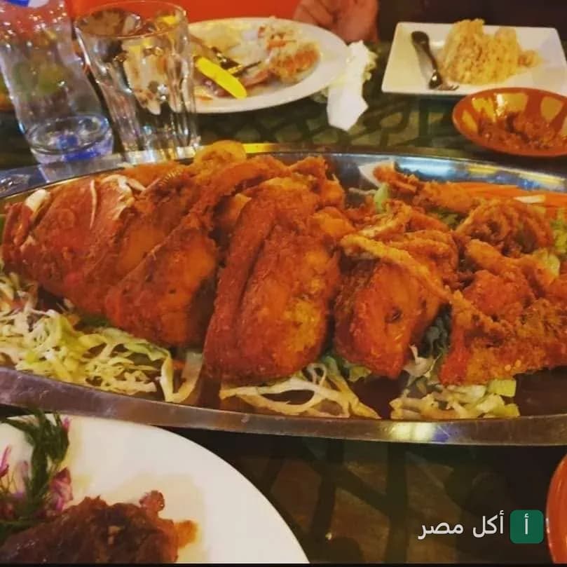 طبق سمك مقلي مقرمش يقدم على سرير من السلطة في مطعم شارك دهب.