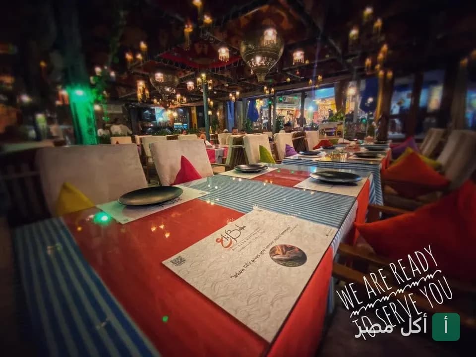 طاولات طعام مرتبة في مطعم علي بابا بدهب مع إضاءة شرقية دافئة وأجواء مريحة.
