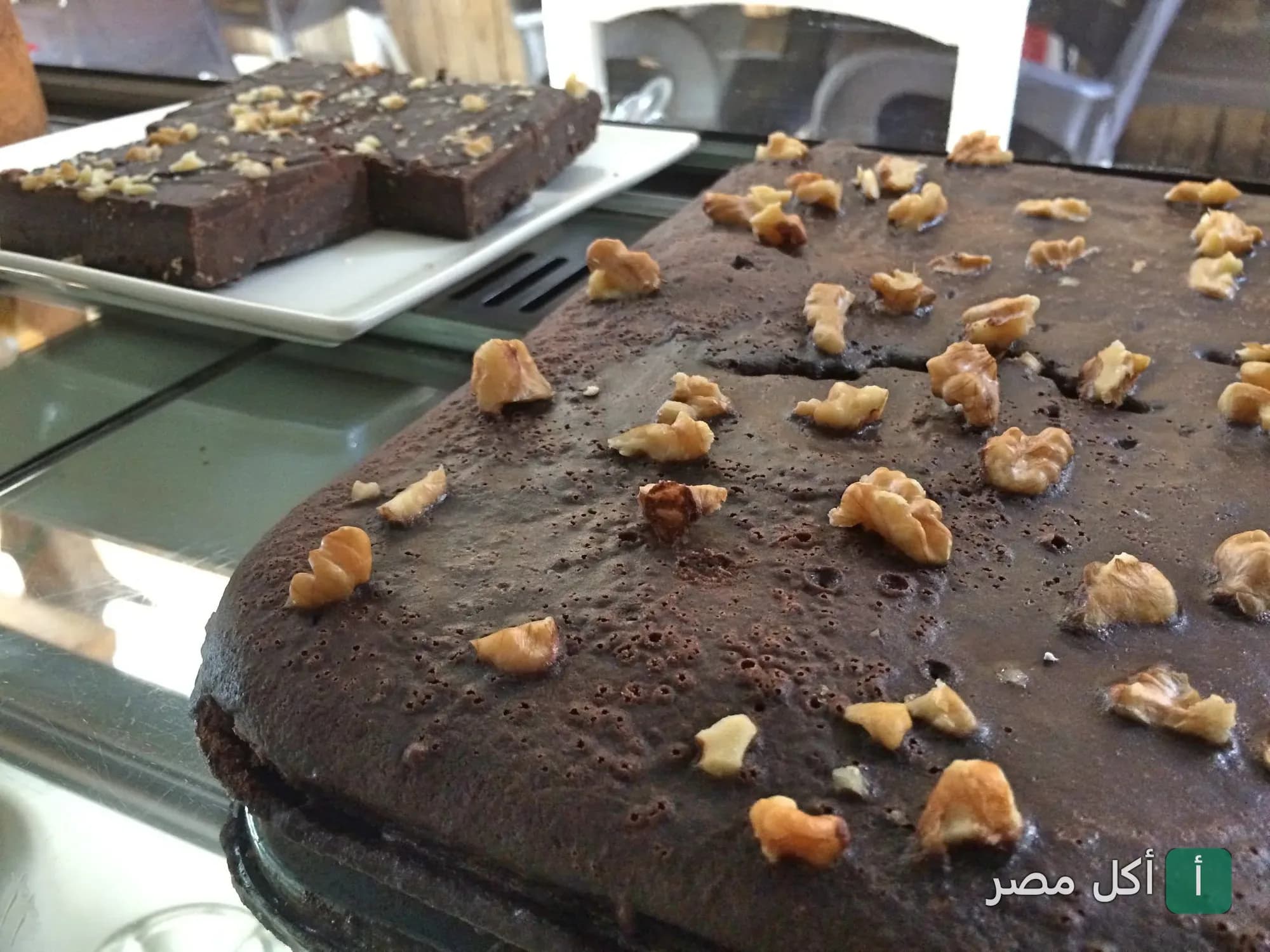قطع براونيز بالشوكولاتة وعين الجمل في واجهة عرض أثانور بيتزيريا بدهب.