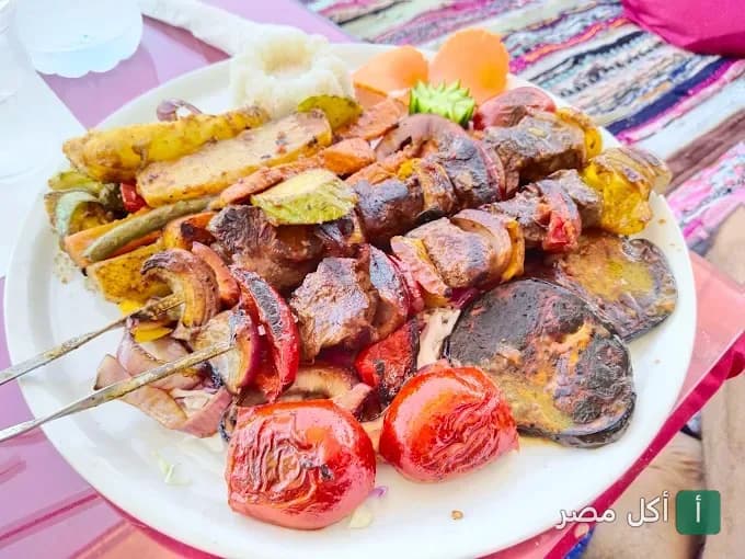 طبق مشويات متنوع يضم أسياخ لحم وخضروات مشوية في مطعم إيل جاردن فيو بدهب.