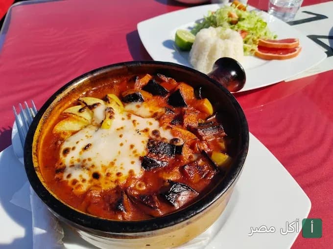طاجن خضار بالصلصة والجبن في مطعم إيل جاردن فيو بدهب مع طبق أرز وسلطة.