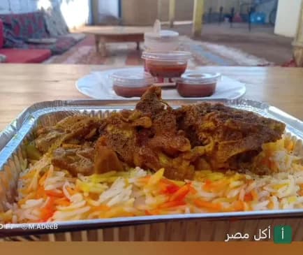 وجبة أرز باللحم في علبة ألومنيوم مع صوصات جانبية في مطعم السلطان بدهب