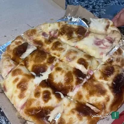 بيتزا شرقي ساخنة بجبنة سايحة في علبة كرتون من مطعم وحوح في 15 مايو.