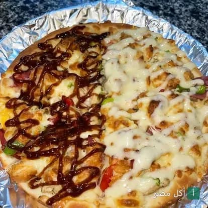 بيتزا مقسمة لنصفين بصوص الباربكيو والجبنة من مطعم وحوح في 15 مايو.
