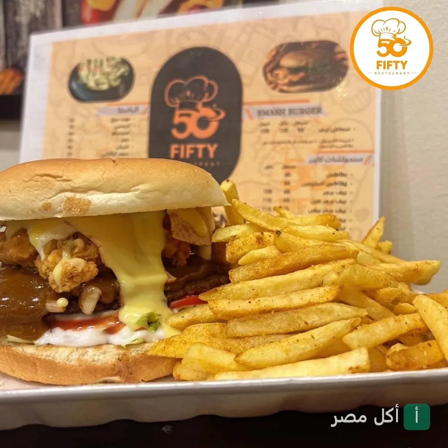 ساندوتش برجر مع صوص الجبنة والبطاطس المقلية من مطعم فيفتي 50 في 15 مايو.