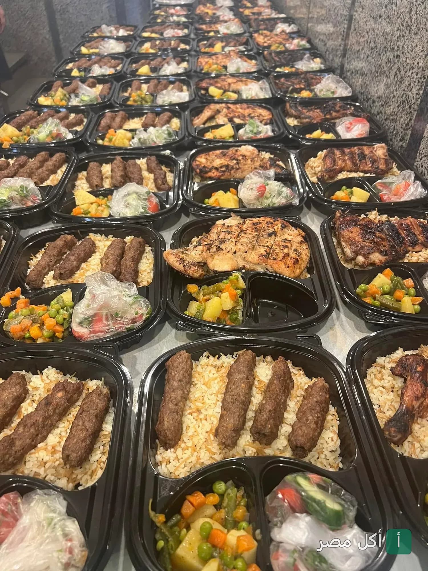وجبات جاهزة من مطعم النجاح بالأزبكية تحتوي على كفتة أو دجاج مشوي مع أرز وخضار.