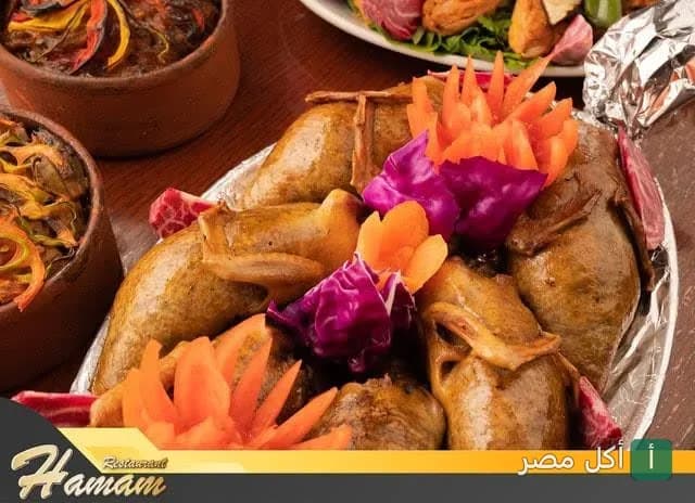 طبق حمام محشي يقدمه رستوران همام في الأزبكية مع مقبلات جانبية.