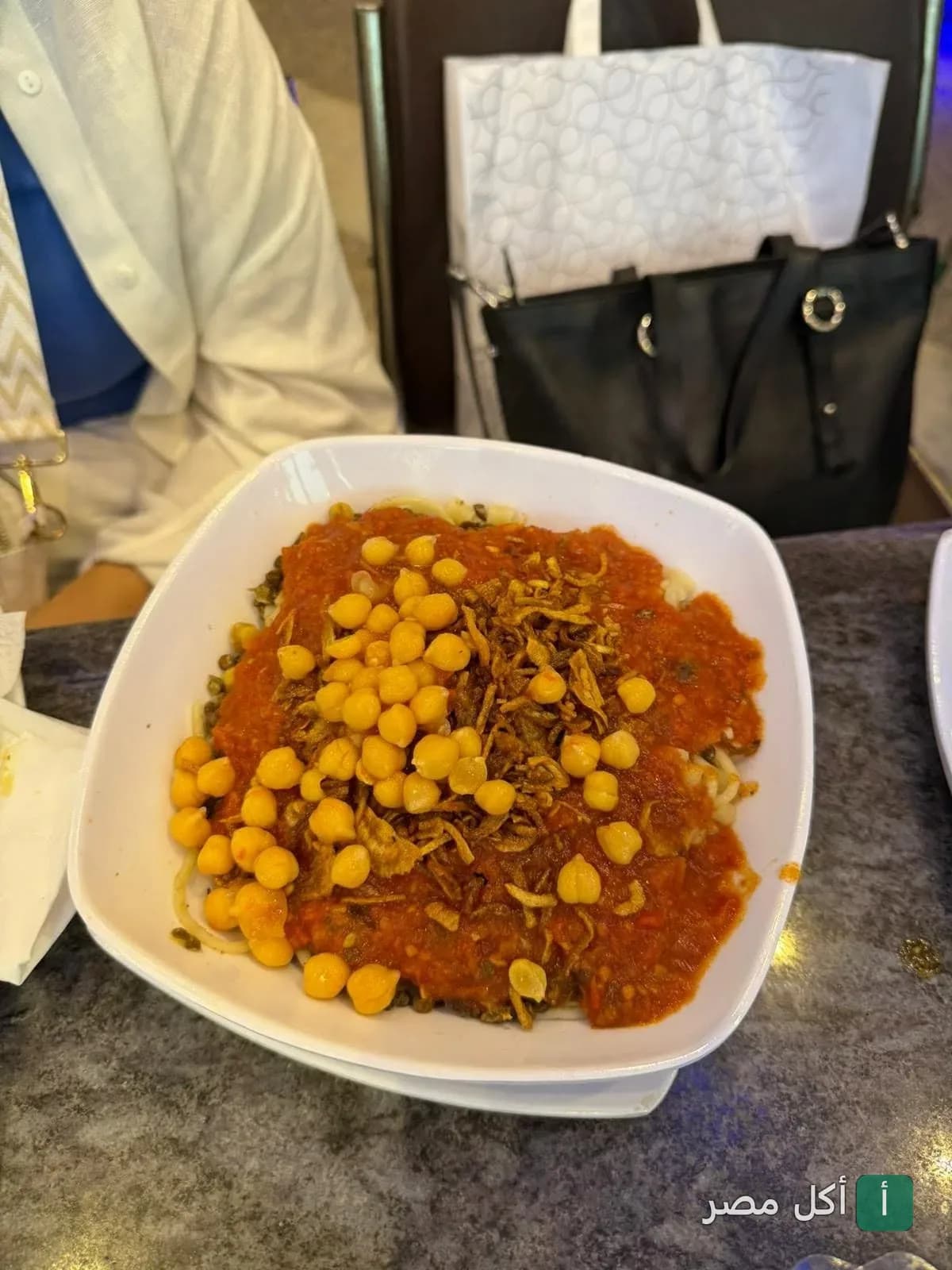 طبق كشري مصري بصلصة الطماطم والحمص والبصل المقرمش في مطعم كشري ابو طارق بالأزبكية.