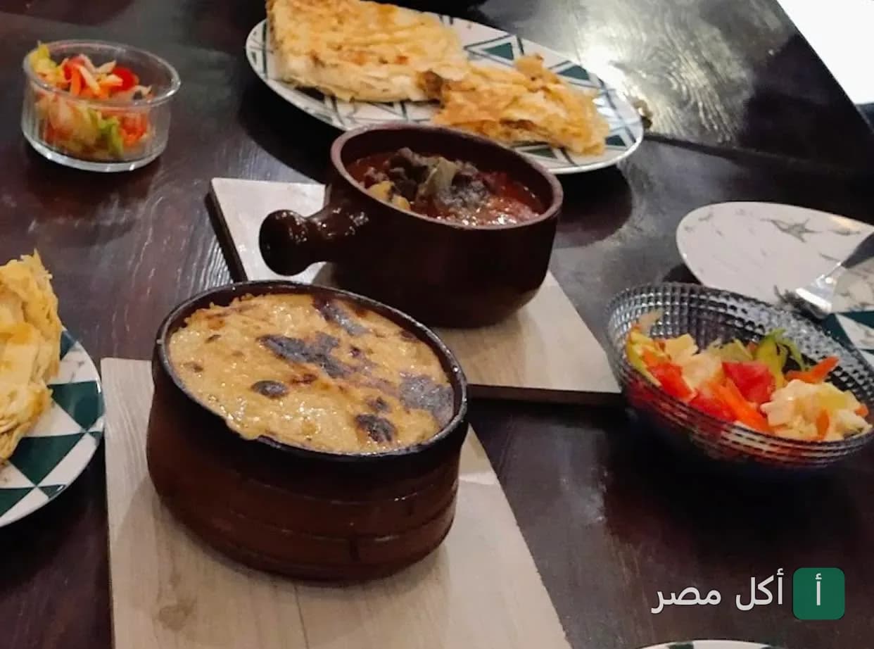 طواجن مصرية متنوعة مع سلطة وفطير على طاولة في مطعم طشة بالأزبكية.