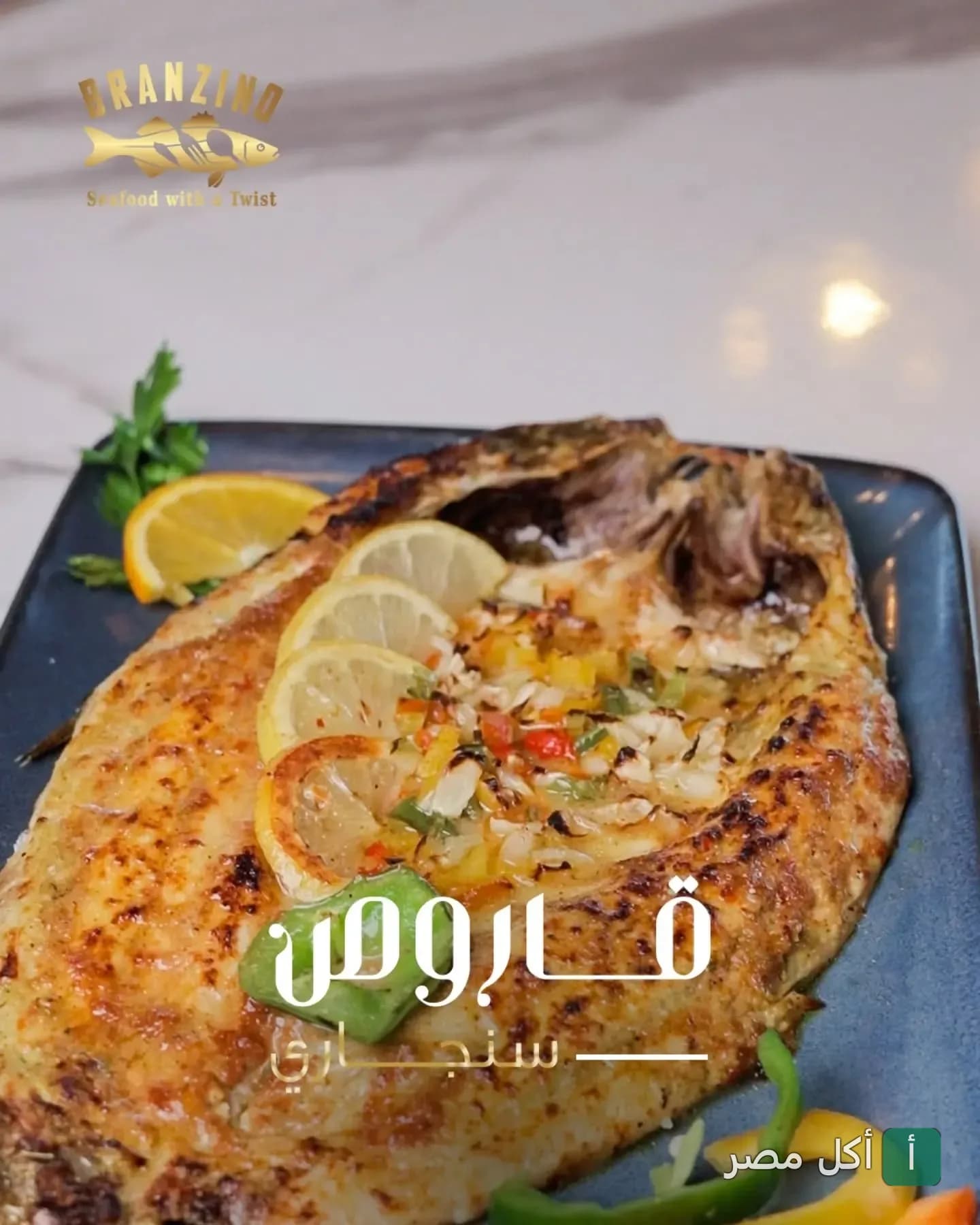 سمكة برانزينو مشوية على الطريقة السنجاري مزينة بشرائح الليمون والفلفل في مطعم برانزينو بالإسكندرية.