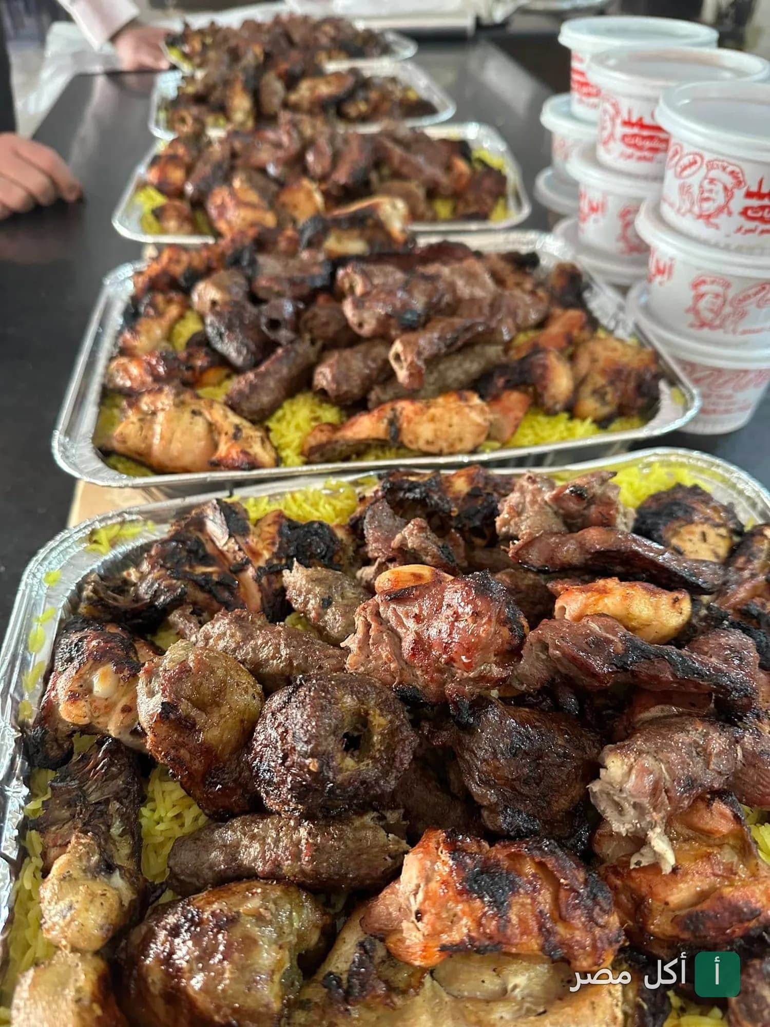أطباق مشويات متنوعة من مطاعم ابو احمد في البساتين مع أرز أصفر وعلب تغليف