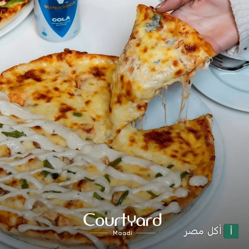 شريحة بيتزا بالجبنة تم رفعها من طبق في مطعم كورت يارد المعادي.