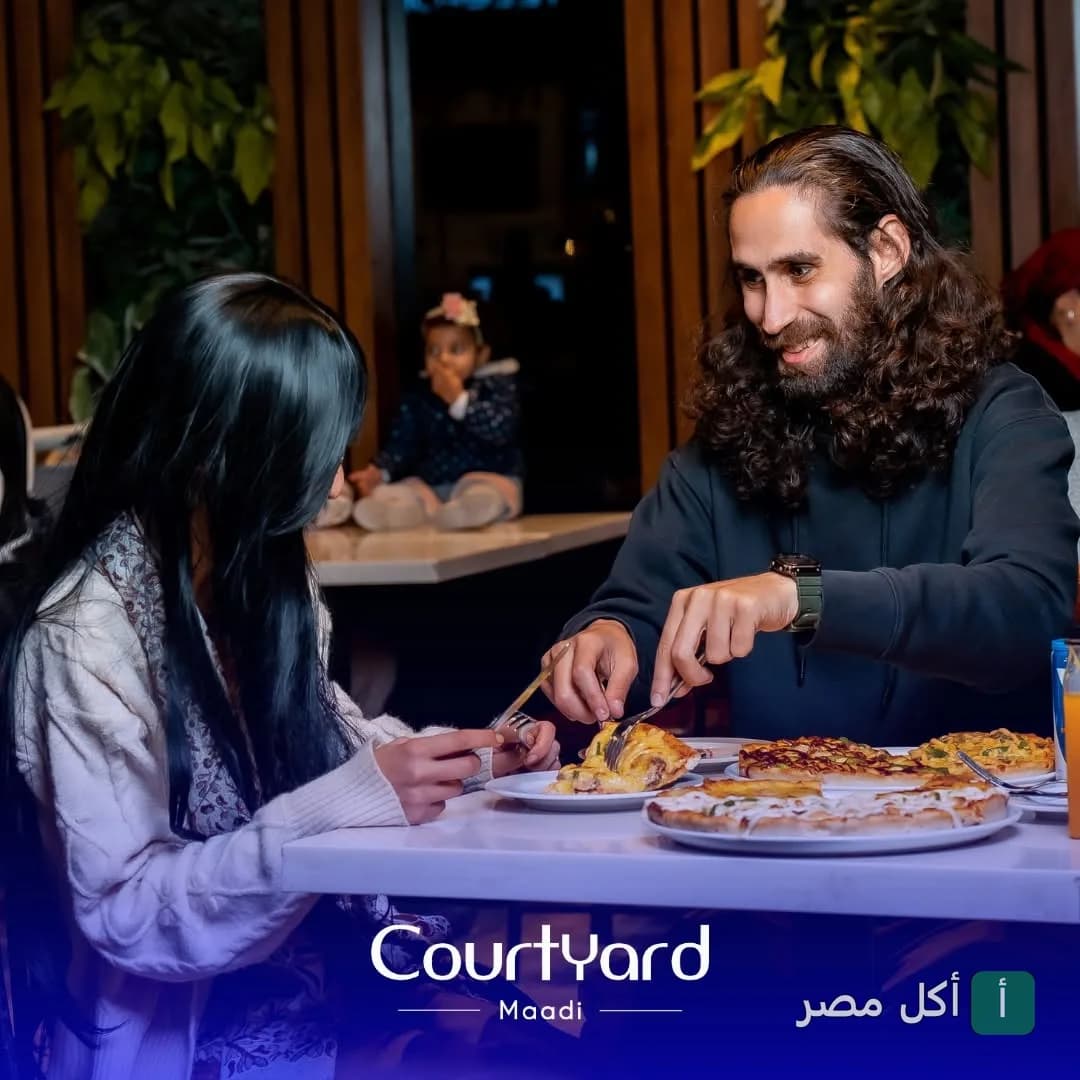 شاب وفتاة يتناولان البيتزا في مطعم كورت يارد المعادي