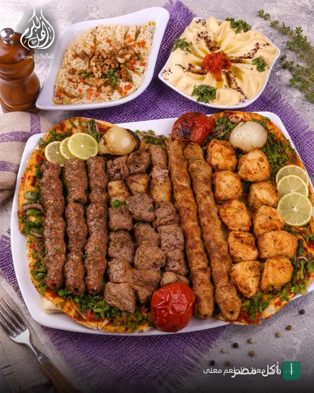 طبق مشاوي مشكل يضم كفتة وشيش طاووق وقطع لحم مع مقبلات مثل الحمص في مطعم أهل الكرم بزهراء المعادي.