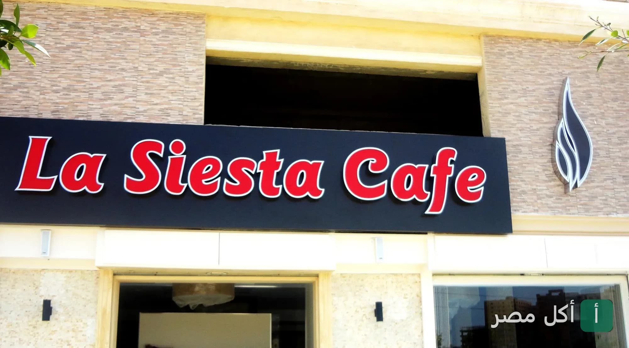 واجهة مطعم لاسيستا في البساتين مع لافتة مكتوب عليها La Siesta Cafe