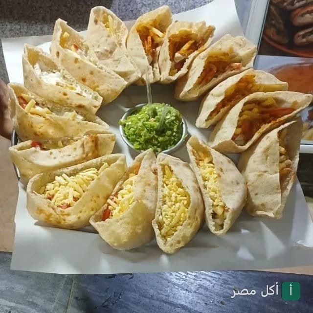 طبق ساندوتشات بطاطس في خبز بلدي مع صوص أخضر في مطعم بطاطس السعد بالبساتين