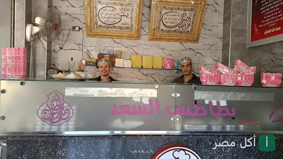موظفو مطعم بطاطس السعد في البساتين يقفون خلف كاونتر التقديم داخل المطعم.
