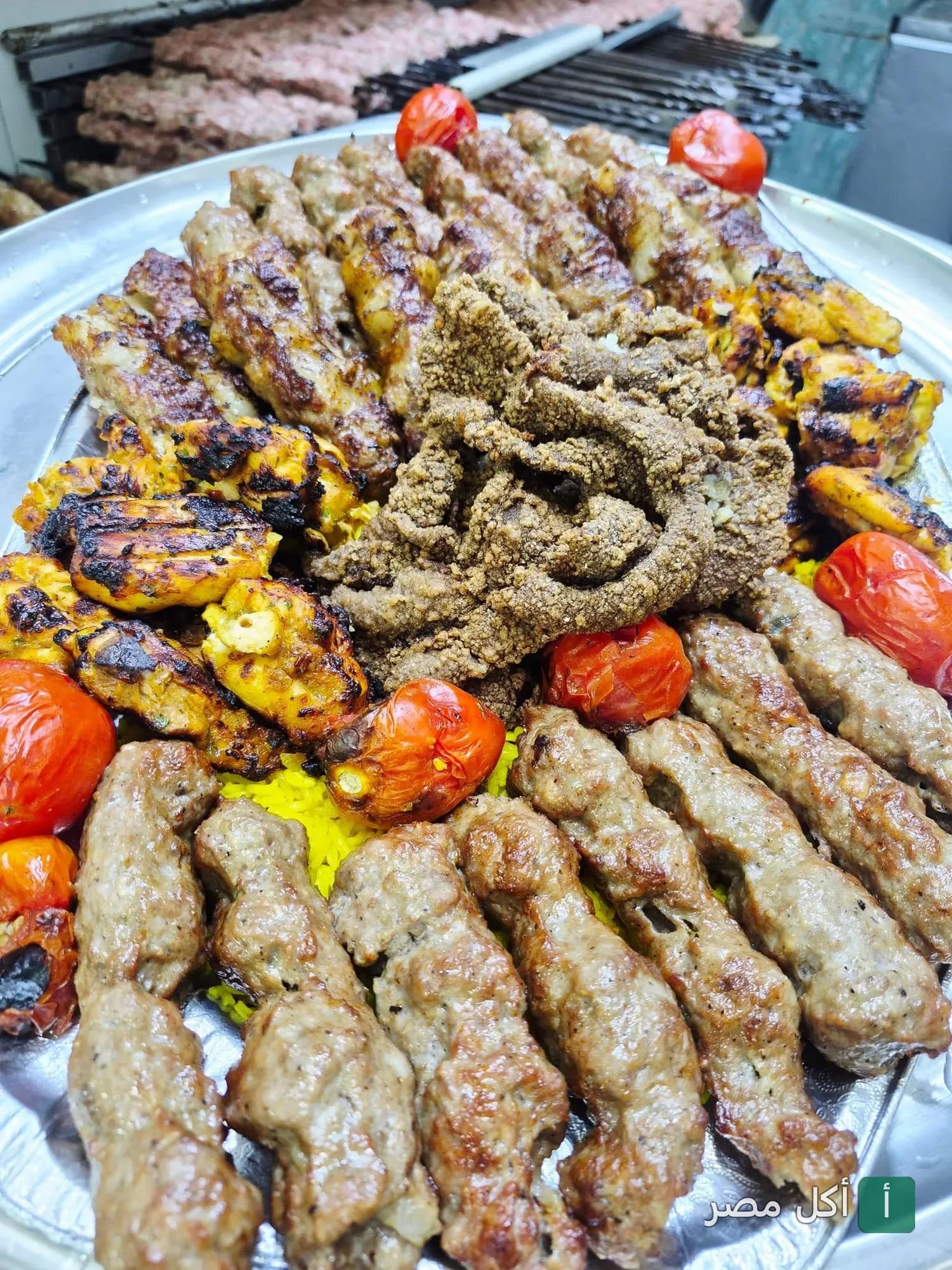 صينية مشاوي مشكلة تضم الكفتة والطرب وقطع الدجاج المشوي مع الطماطم في مطعم كاسب بالزقازيق.
