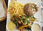 طبق مشويات مع أرز وبطاطس مقلية وصوصات في مطعم ستيريو الزقازيق