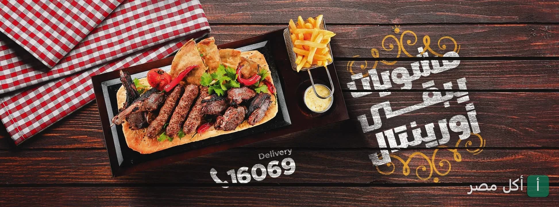 طبق مشويات متنوع مع بطاطس مقلية على طاولة خشبية في مطعم مشويات أورينتال بالزقازيق.