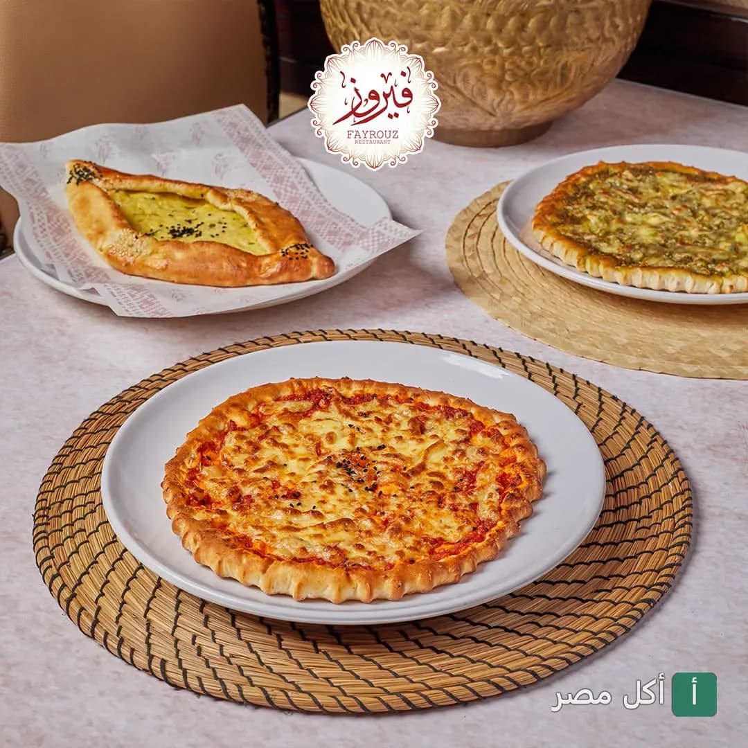 تشكيلة من المعجنات والمخبوزات على أطباق بيضاء في مطعم فيروز.