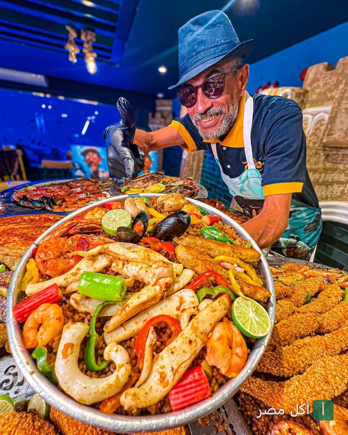 شيف مطعم بهيج ملك الفسفور العجيب يقدم صينية مأكولات بحرية متنوعة تحتوي على جمبري وسمك ومحار.