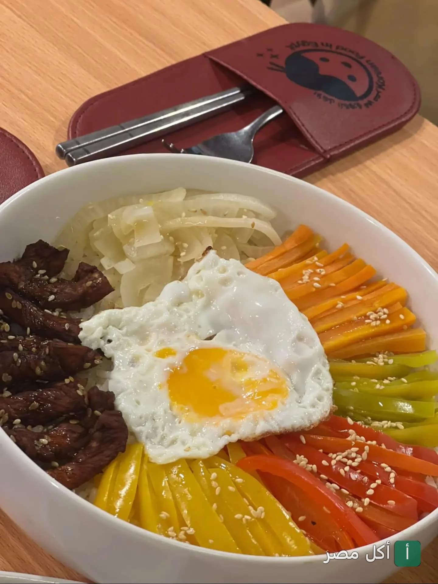 طبق بيبيمباب كوري ببيض مقلي وخضروات ملونة ولحم في مطعم كوريان فود إن إيجيبت بالجيزة.