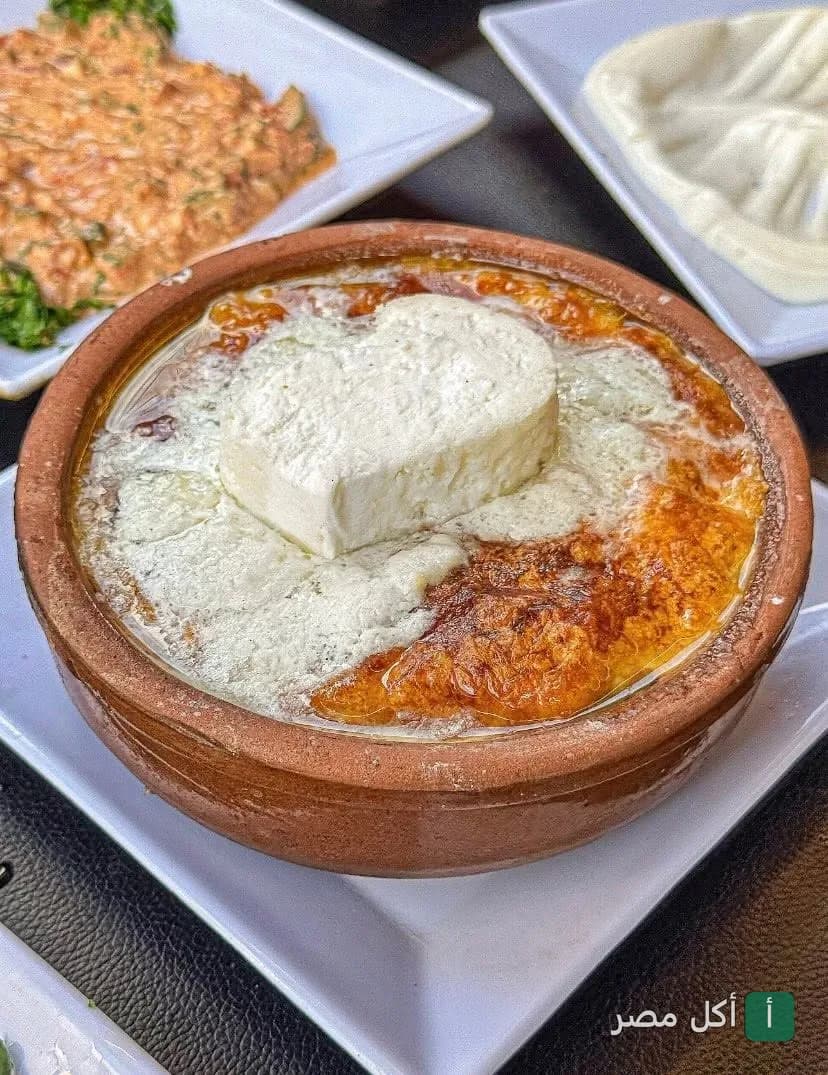 طاجن مصري ساخن مغطى بقطعة جبنة بيضاء في مطعم كبابجي الوحش بالعطارين