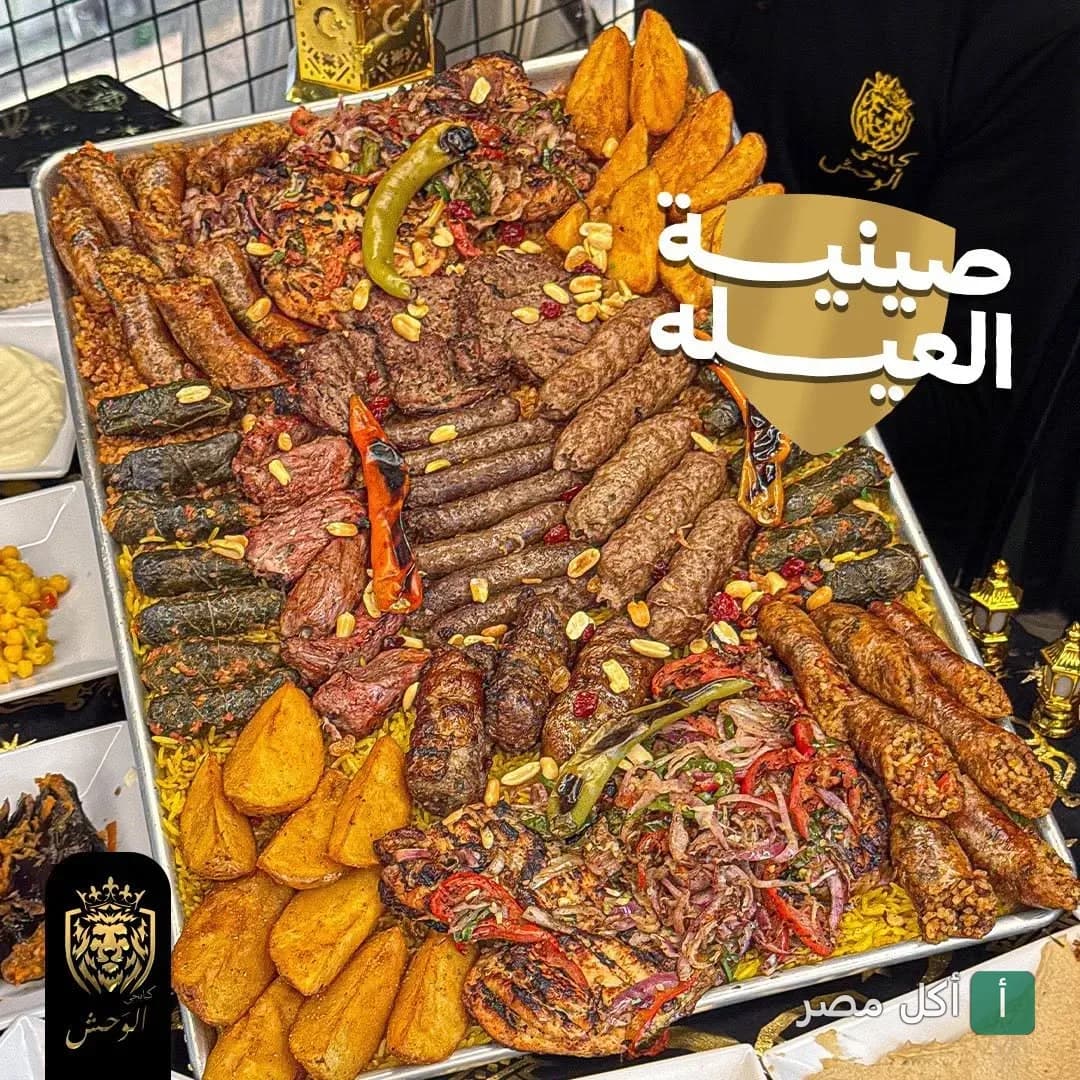 صينية مشاوي مشكلة من كبابجي الوحش بالعطارين، تحتوي على كفتة، طرب، ورق عنب، وبطاطس محمرة.