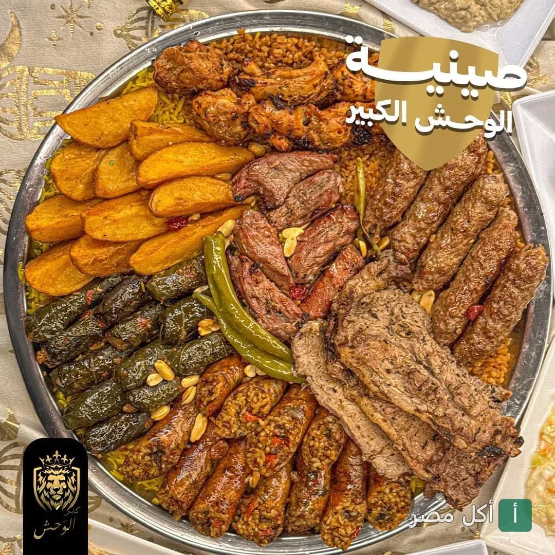 صينية مشاوي مشكلة من كبابجي الوحش تضم كباب وكفتة وورق عنب وممبار وبطاطس محمرة.