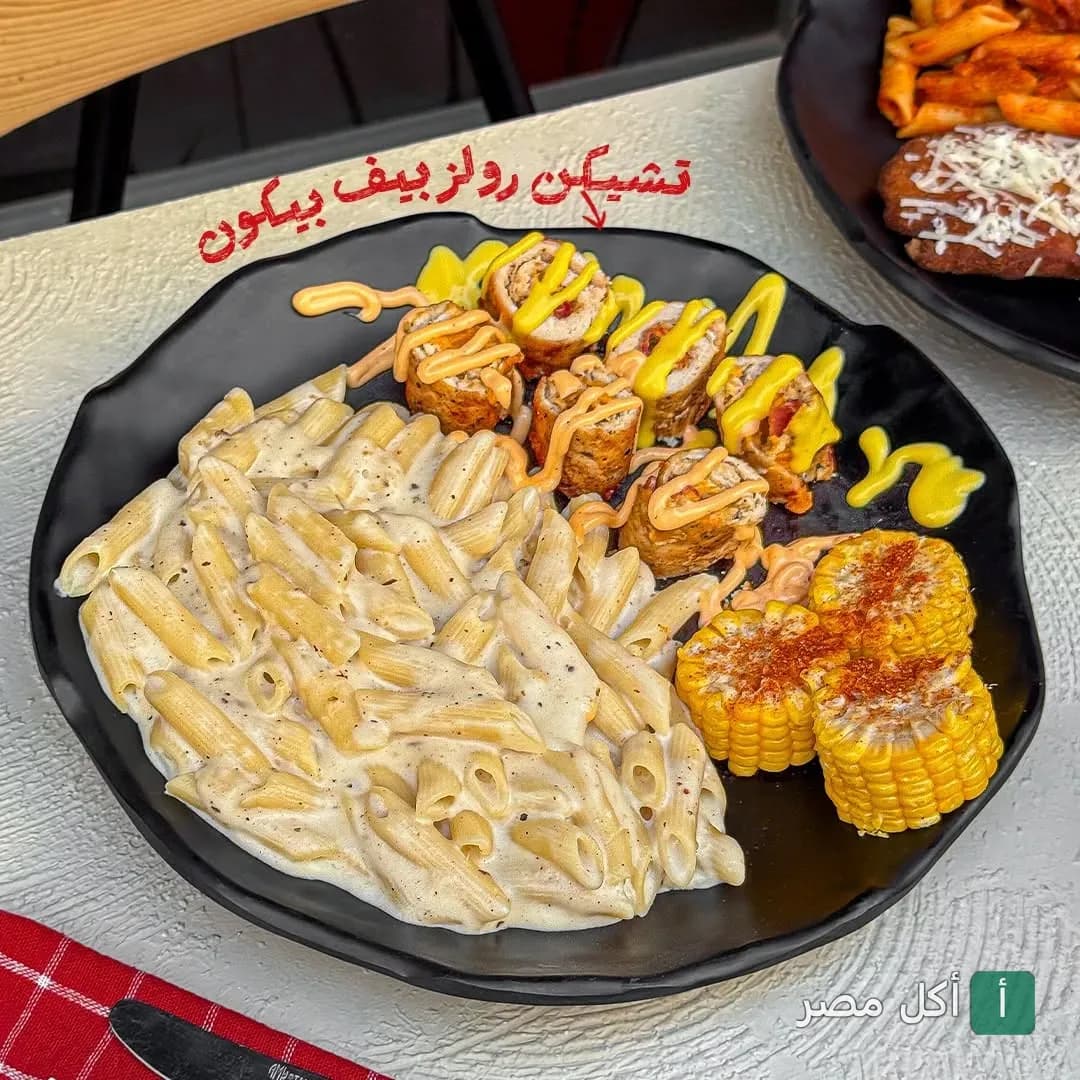طبق تشيكن رول بيف بيكون مع مكرونة بالصوص الأبيض وذرة مشوية في مطعم بوتاستا بسان ستفانو.
