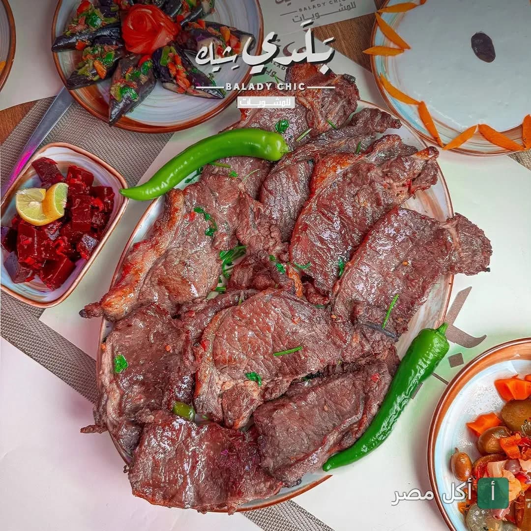 طبق مشاوي مشكل من مطعم بلدي شيك في الرمل مع مقبلات متنوعة.