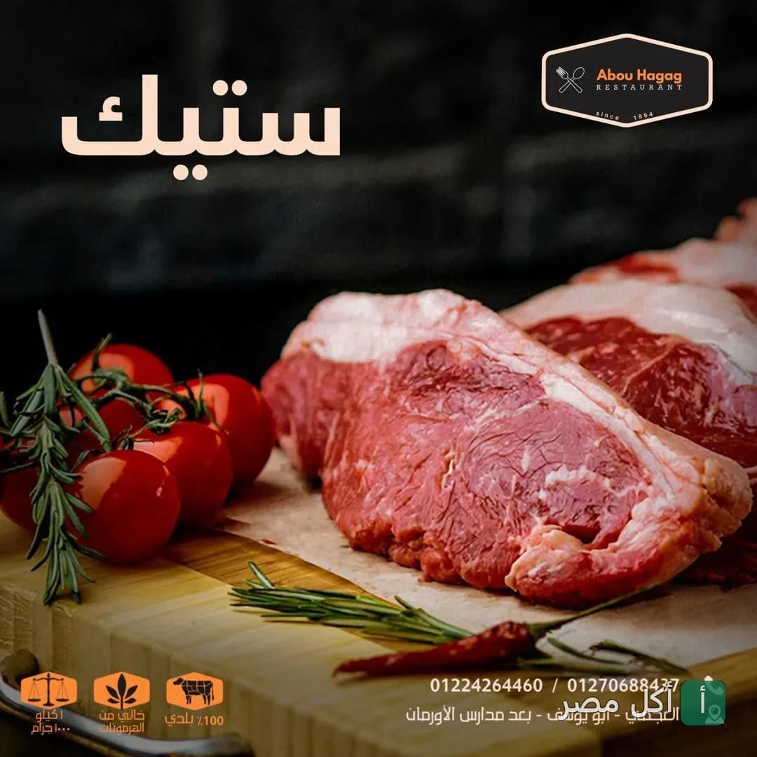قطع ستيك لحم طازجة مع طماطم وروز ماري على لوح تقطيع في مطعم أبو الحاج للمشويات بالعامرية.