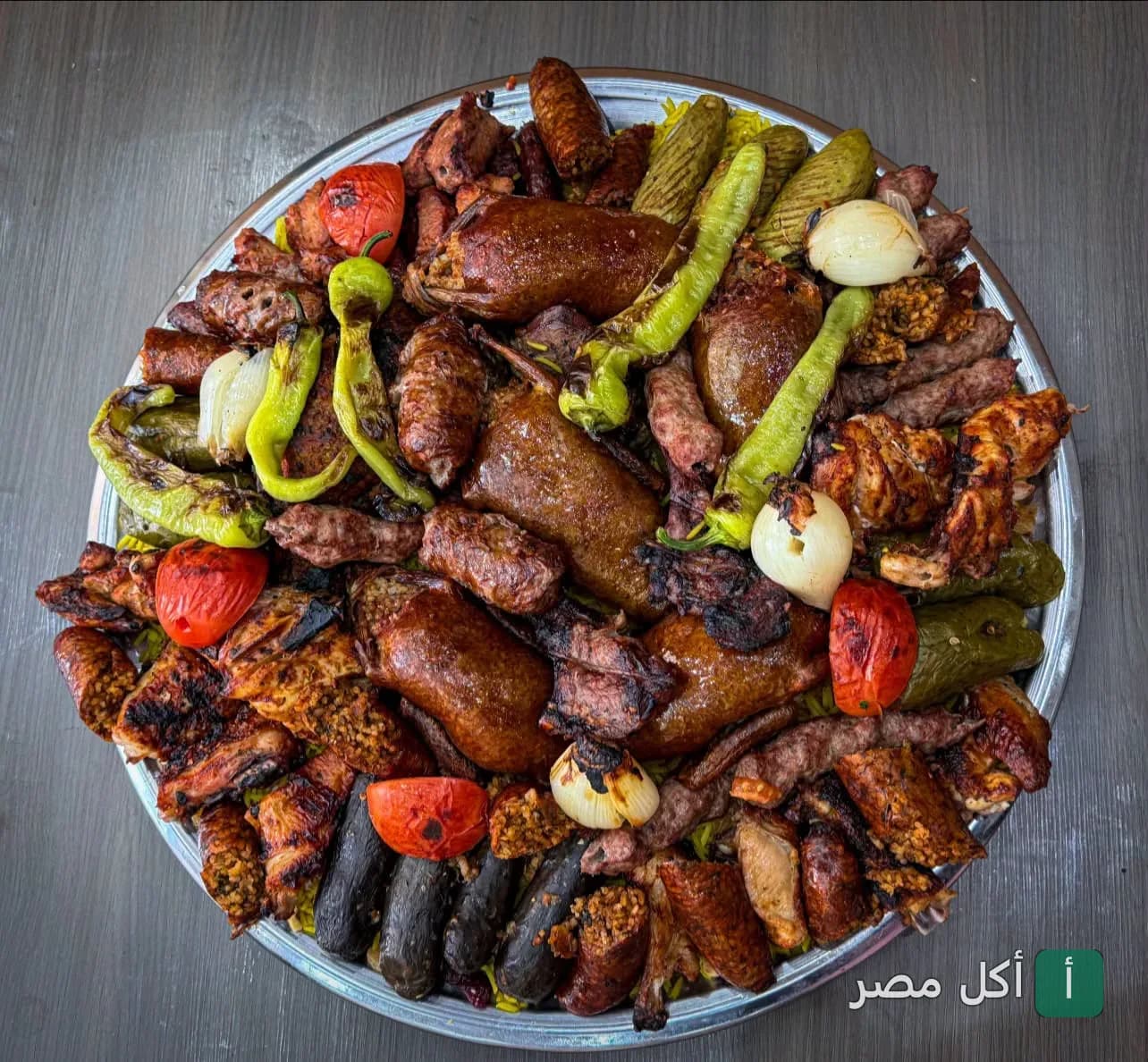 صينية مشويات مشكلة من جراند شاورما بور فؤاد تضم كفتة، طرب، ومحاشي مع خضار مشوية.